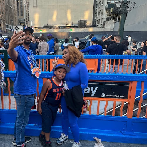 New York Knicks fans pose at a subway entrance in New York decorated in team colors as the Knicks play the San Antonio Spurs in Game 1 of the NBA Finals basketball series on Wednesday, June 3, 2026. (AP Photo/Ted Shaffrey)