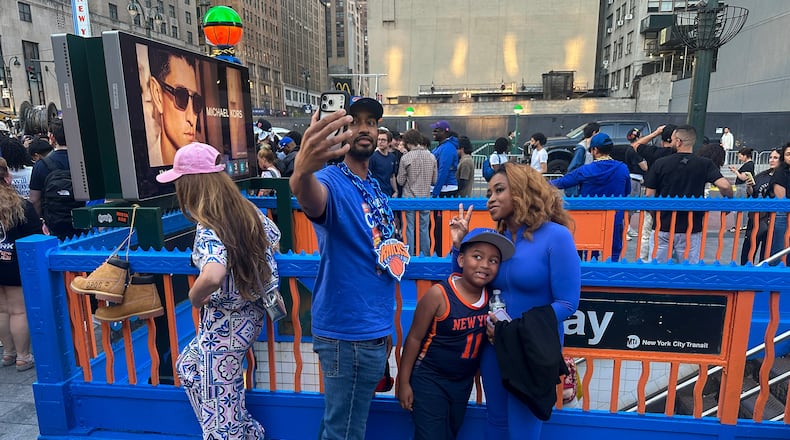 New York Knicks fans pose at a subway entrance in New York decorated in team colors as the Knicks play the San Antonio Spurs in Game 1 of the NBA Finals basketball series on Wednesday, June 3, 2026. (AP Photo/Ted Shaffrey)