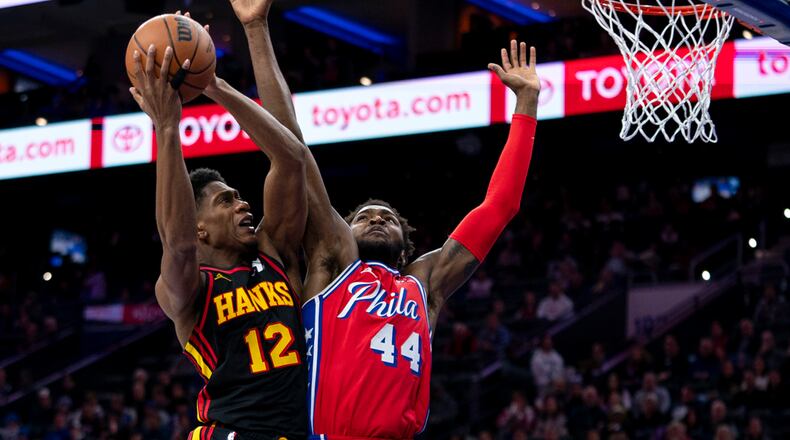 Atlanta Hawks' De'Andre Hunter, left, shoots against Philadelphia 76ers' Paul Reed during the first half of an NBA basketball game Friday, Dec. 8, 2023, in Philadelphia. (AP Photo/Chris Szagola)