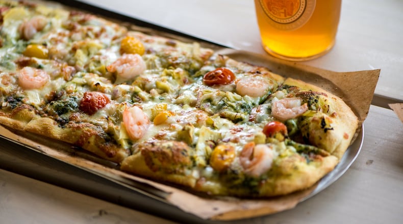 Slim and Husky's California Love pizza with spinach basil pesto, house cheese blend, artichoke, sliced tomato blend, red onion, and shrimp. Photo credit- Mia Yakel.