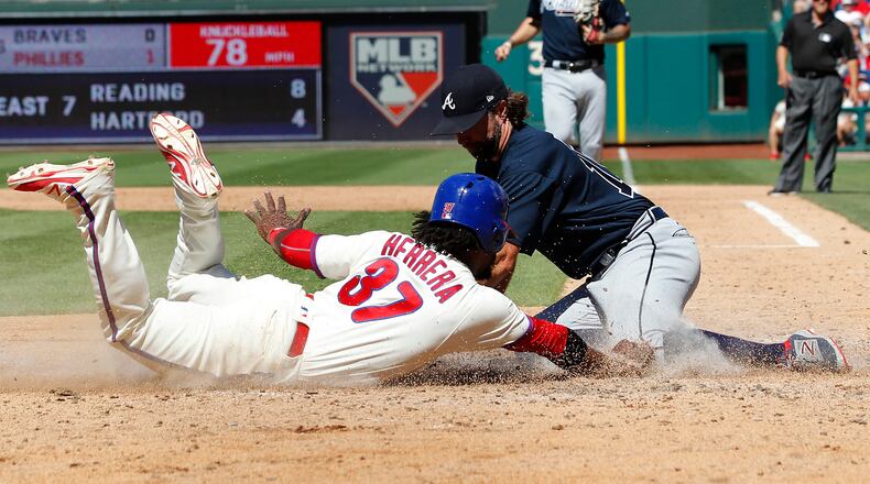 Odubel Herrera of the Phillies is tagged out at home by Braves pitcher R.A. Dickey after a wild pitch during the sixth inning of a baseball game against the Atlanta Braves, Sunday, July 30, 2017, in Philadelphia.