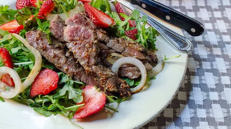 Sweet tart strawberries are paired with grilled skirt steak, Vidalia onions and balsamic vinaigrette for a hearty salad supper.
(Virginia Willis for The Atlanta Journal-Constitution)