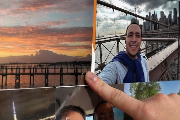 The girlfriend of Juan Serrano, a 28-year-old Colombian migrant with no criminal record who was detained Wednesday, May 21, 2025, at Miami Immigration Court after appearing for a hearing, points to a picture of the barrier island where the pair met while working on a cleanup and demolition crew following 2022's Hurricane Ian, inside their apartment in Oakland Park, Fla. (AP Photo/Rebecca Blackwell)