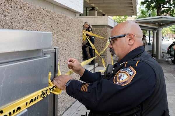 Law enforcement work outside the family courthouse at San Jacinto and Franklin after a Harris County sheriff's deputy was shot, as was the suspected shooter, in Houston, Monday, April 21, 2025. (Yi-Chin Lee/Houston Chronicle via AP)