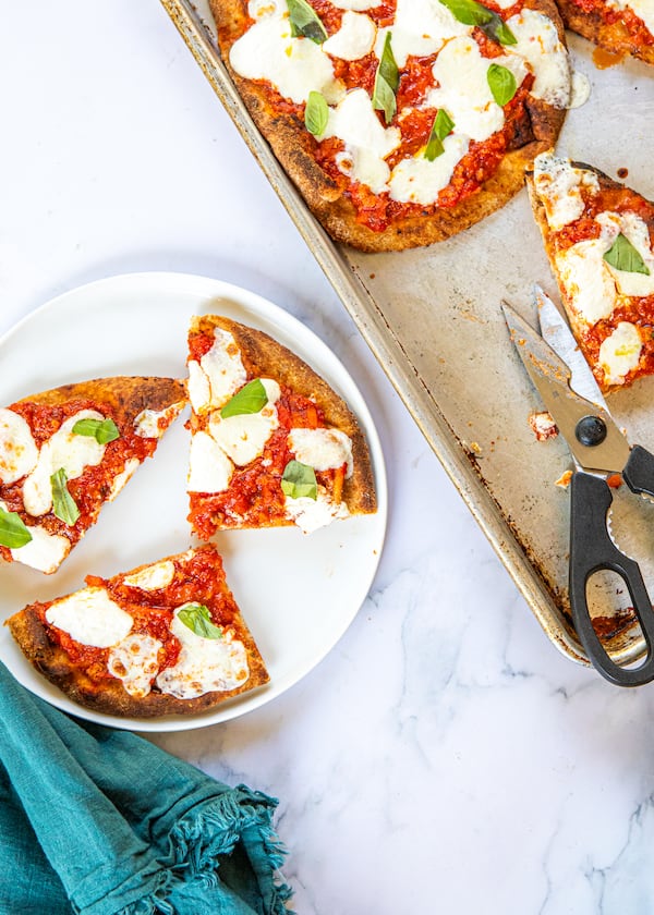 Naan provides a simple stand-in for the crust in homemade versions of the Bolognese pizza from Lloyd's Restaurant and Lounge in Inman Park. (Credit: Aaliyah Mann for the AJC, styling by Kate Itrich-Williams)