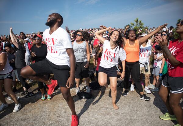 David Bryant (L) and Adelaide Leao (C) worship together during the start of the OneRace event on top of Stone Mountain Saturday. 