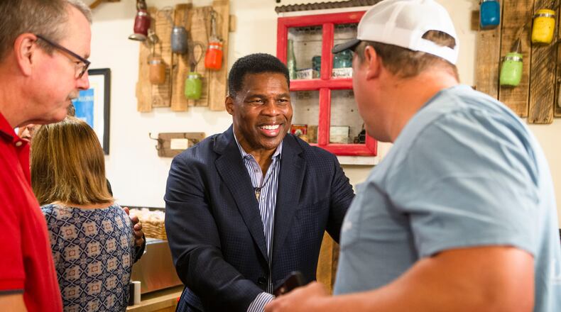 Josh Brice (right), a Gainesville resident, meets Herschel Walker (middle), while Fletcher Law (right), a Gainesville resident, waits in line during a meet and greet event on Wednesday, July 27, 2022, at Longstreet Cafe in Gainesville, Georgia. Fox & Friends broadcasted live from the restaurant during which co-host Brian Kilmeade interviewed Walker. CHRISTINA MATACOTTA FOR THE ATLANTA JOURNAL-CONSTITUTION.