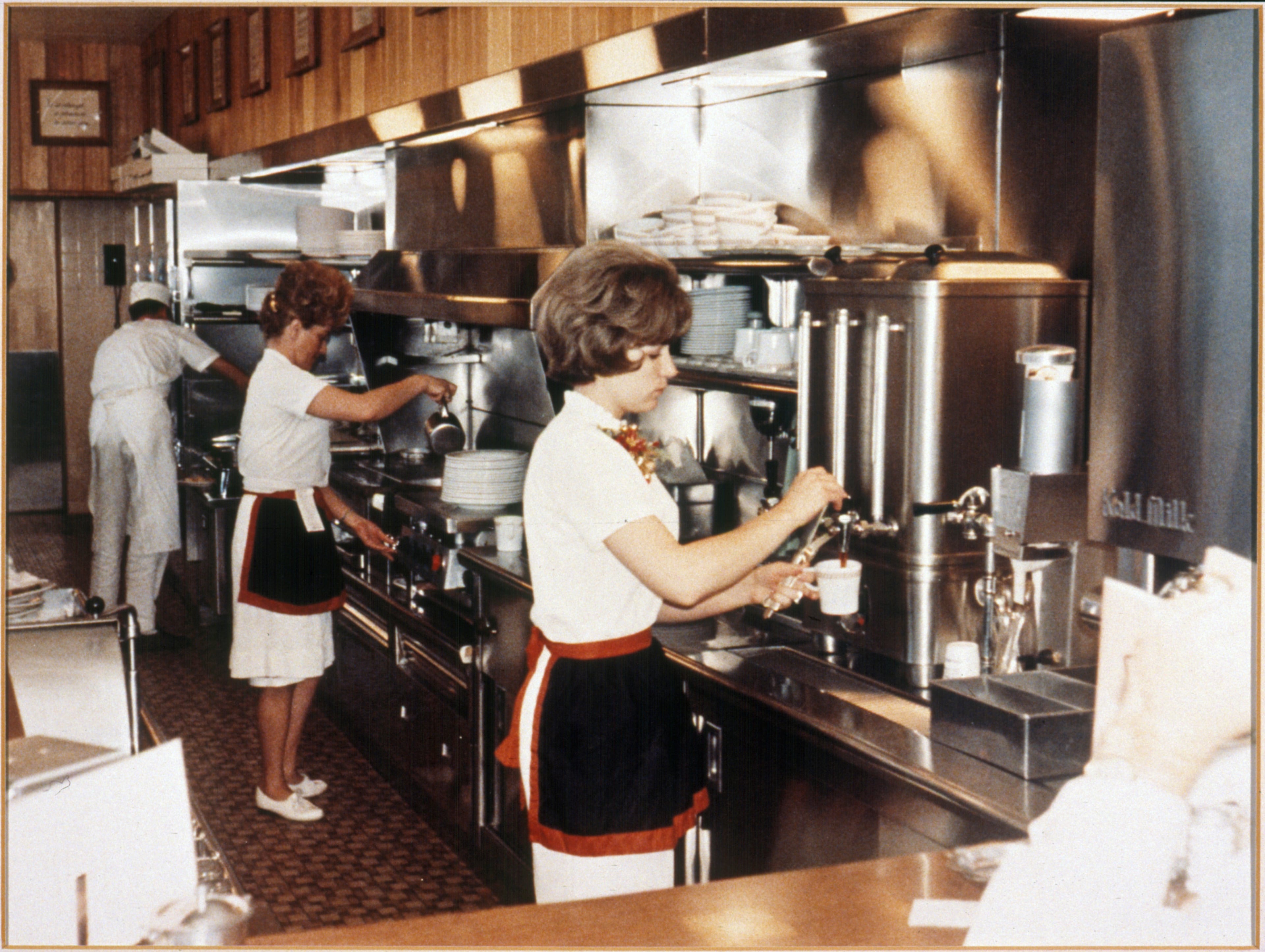 1960s: Waitresses pour coffee at Waffle House.