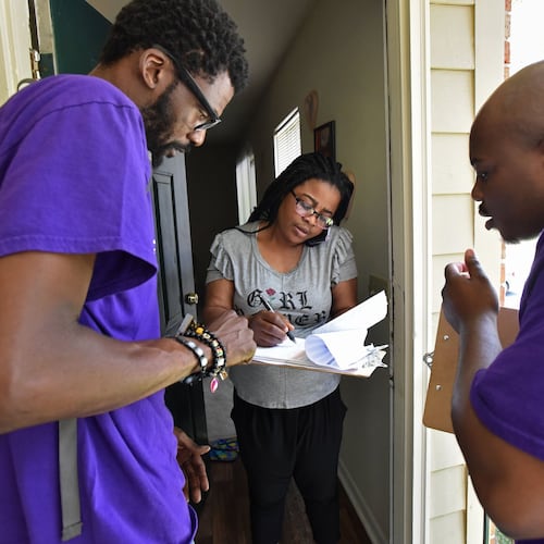 Rodney King (left), volunteer with New Georgia Project, and Corbin Spencer (right), field director of New Georgia Project, help Rueke Uyunwa register to vote in 2017. (Hyosub Shin/AJC)