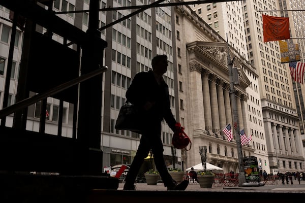 People walk past the New York Stock Exchange, Thursday, April 10, 2025, in New York. (AP Photo/Yuki Iwamura)