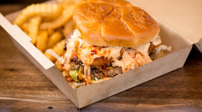 Slutty Vegan Ménage à Trois is a plant based patty loaded with vegan bacon and shrimp, topped with lettuce tomato and special sauce. Photo credit- Mia Yakel.