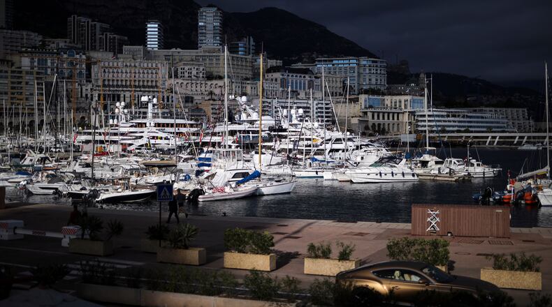 FILE - A luxury car drives along Monaco Harbor, Nov. 19, 2020. (AP Photo/Daniel Cole, File)
