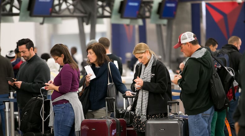 Delta passengers wait in line at Hartsfield-Jackson International earlier this month. BRANDEN CAMP/SPECIAL