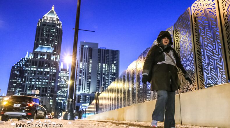 Karen Bolen walks along 14th Street in Midtown, where ice remained after Friday’s storm.