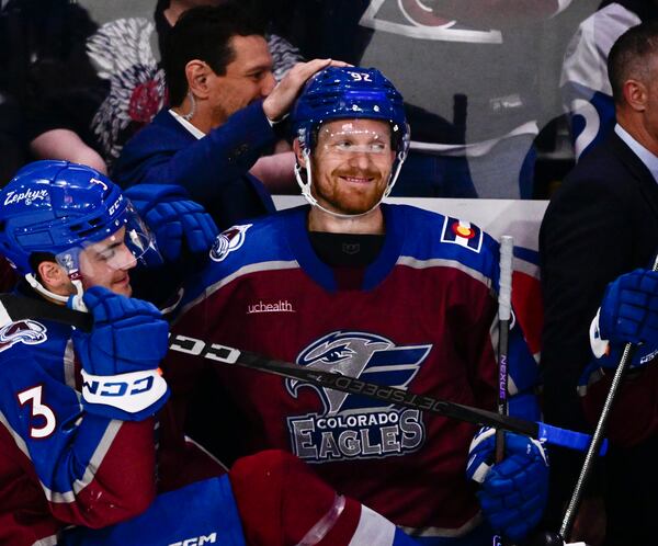 Colorado Eagles forward Gabriel Landeskog, center, gets a pat on the head from assistant head coach Dan Hinote after a minor league hockey game Friday, April 11, 2025, in Loveland, Colo. (Andy Cross/The Denver Post via AP)