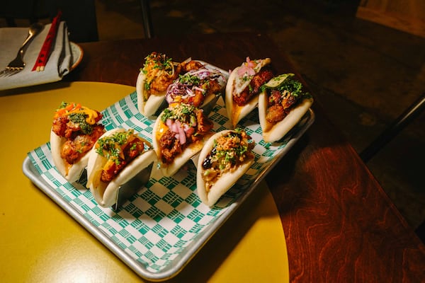 A selection of eight bao buns on a tray on a restaurant table.