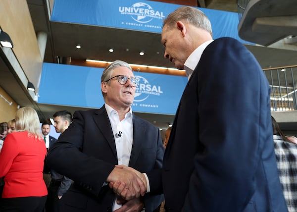 British Prime Minister Keir Starmer, left, shakes hand with President of Comcast Corporation Michael Cavanagh at an announcement that U.S. media giant Comcast Corp will build its first Universal theme park and resort in Europe, opening in 2031, during a visit to Bedford, north of London, Wednesday April 9, 2025. (John Sibley/Pool Photo via AP)
