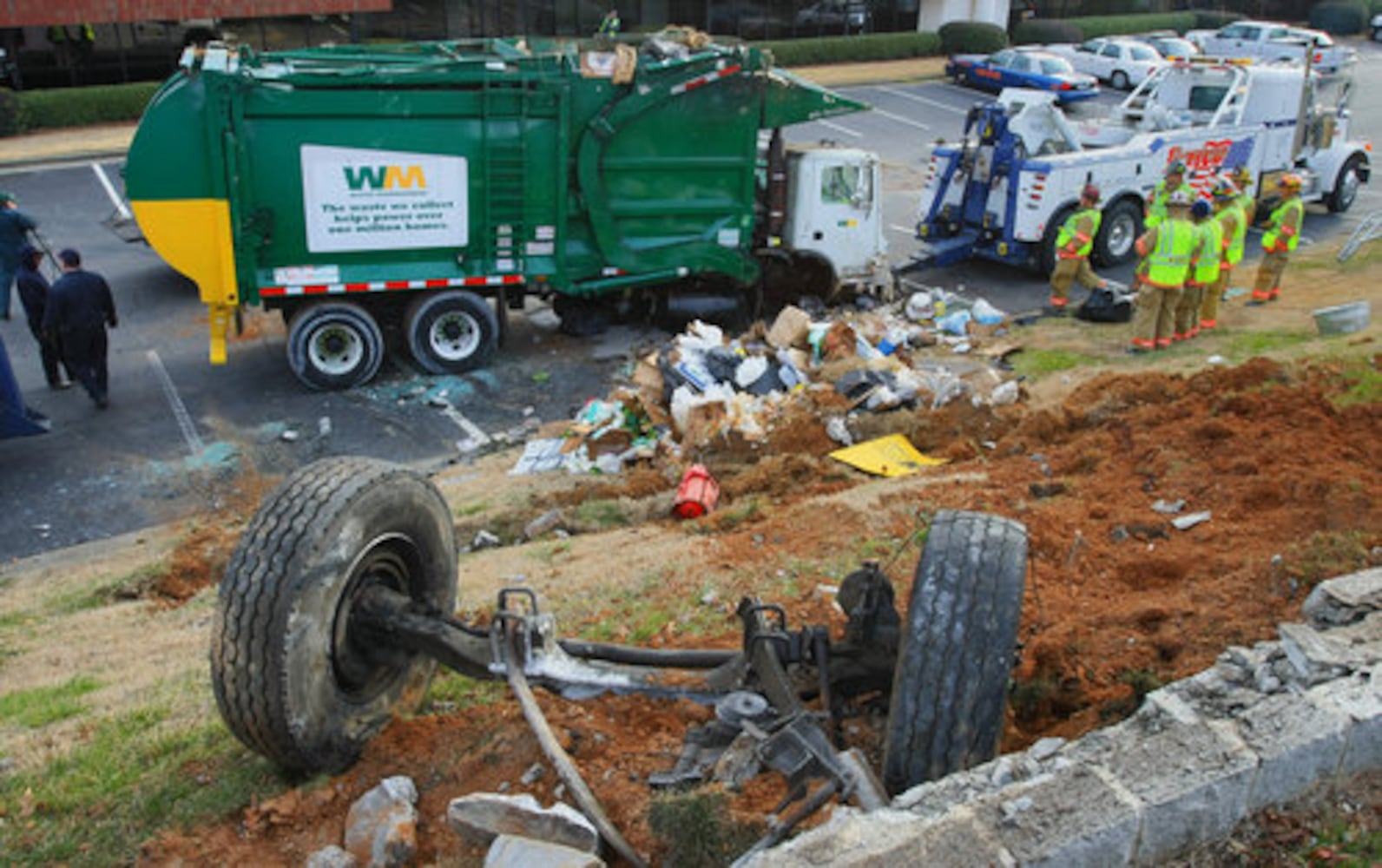 Garbage truck flips down hill, crushes cars