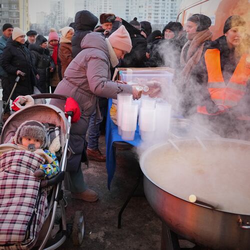 Yuliia Dolotova, 37, receives hot food at a distribution point during a power outage caused by Russia’s repeated air strikes on the country’s power grid, in Kyiv, Ukraine, Monday, Feb. 2, 2026. (AP Photo/Sergey Grits)