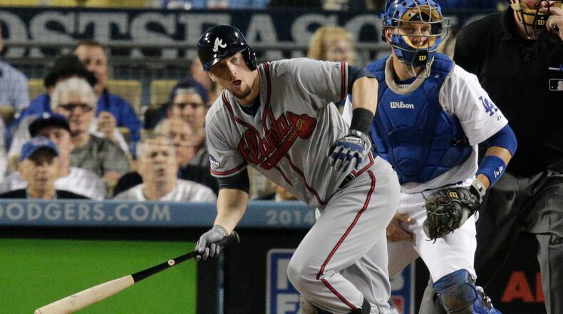 Atlanta Braves' Chris Johnson watches his single that scored Freddie Freeman as Los Angeles Dodgers catcher A.J. stands at right in the fourth inning of Game 4 in the National League baseball division series Monday, Oct. 7, 2013, in Los Angeles.