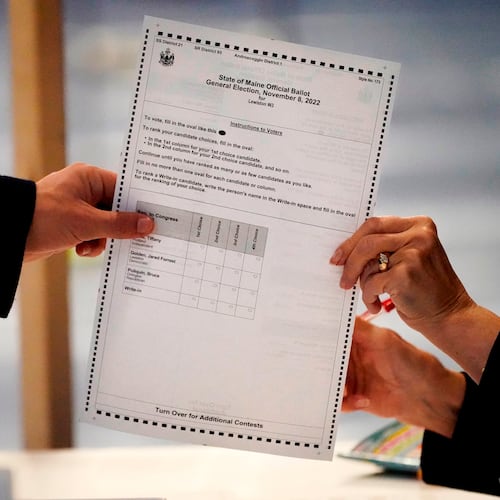 FILE - A ballot is handed to a voter, Nov. 8, 2022, in Lewiston, Maine. (AP Photo/Robert F. Bukaty, File)