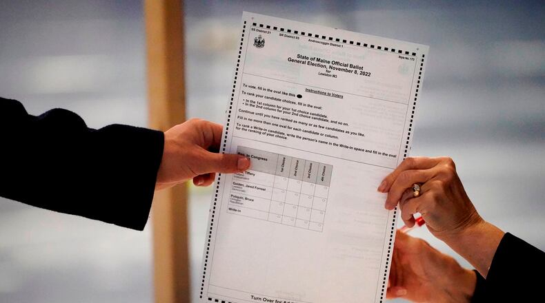 FILE - A ballot is handed to a voter, Nov. 8, 2022, in Lewiston, Maine. (AP Photo/Robert F. Bukaty, File)