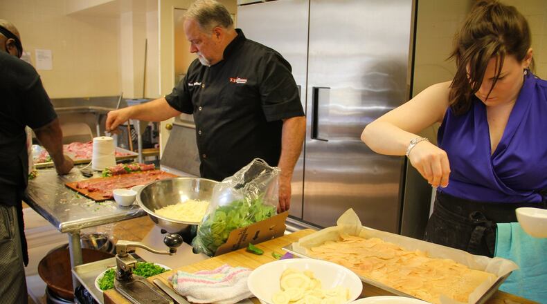 When there’s a catering job at Gathering Industries, it’s all hands on deck. Alex Reethof (center), co-founder of Gathering Industries, works in their commercial kitchen with Amber West, director of operations. (HaydnCorine Media)