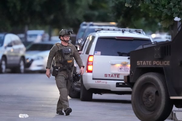 A Louisiana state police SWAT member works the scene on Iberville Street as police pursue a fugitive that escaped from a New Orleans jail, Tuesday, May 20, 2025, in New Orleans. (AP Photo/Gerald Herbert)