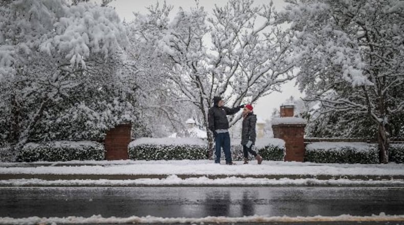 People walk along Shiloh Road in Kennesaw after a snowstorm hit metro Atlanta and North Georgia.