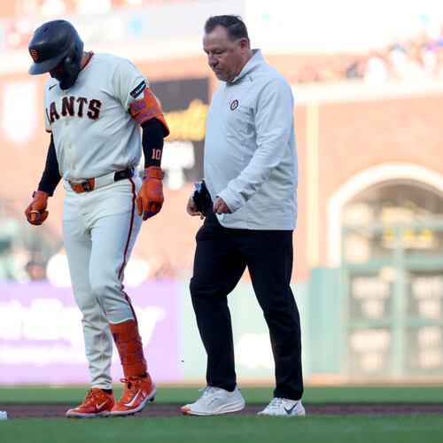 San Francisco Giants' Casey Schmitt, left, walks off the field with an injury accompanied by athletic trainer Dave Groeschner, right, during the second inning of a baseball game against the Milwaukee Brewers in San Francisco, Monday, July 27, 2026. (AP Photo/Jed Jacobsohn)