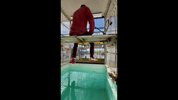 Justin Smith awaits his fate, seated above a tub of water, in the Soak the Bloke booth at the Georgia National Fair. (Joe Kovac Jr./AJC)