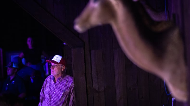 Jay Wallace, owner of gun store and indoor shooting range Adventure Outdoor in Smyrna, watches Tuesday's presidential debate during a Republican watch party at his store. (Arvin Temkar/AJC)