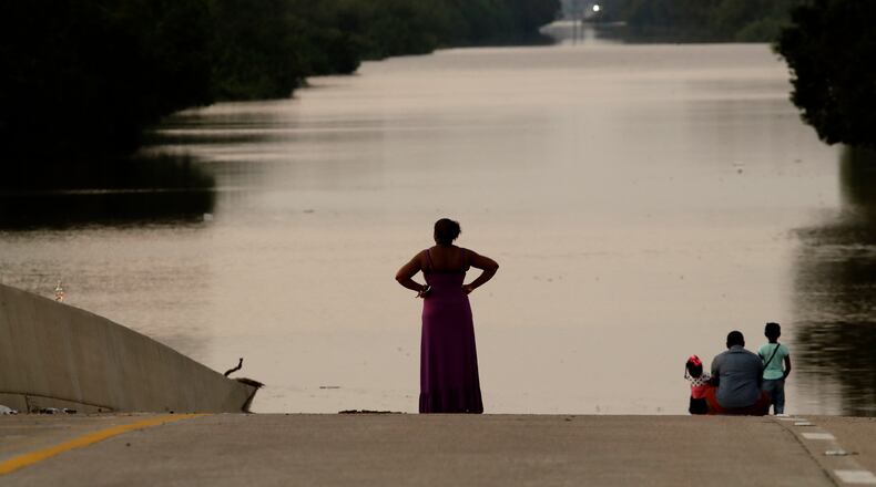 Jessica Anderson, with her husband Darrell and daughters Lauren, and Harper view floodwaters in Addicks Reservoir from a closed freeway in the aftermath of Hurricane Harvey on Friday in Houston. AP/Charlie Riedel