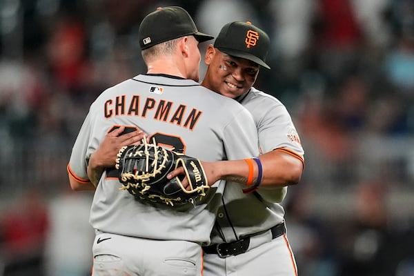 San Francisco Giants' Matt Chapman (26) and Rafael Devers embrace after a baseball game against the Atlanta Braves, Tuesday, July 22, 2025, in Atlanta. (AP Photo/Mike Stewart)