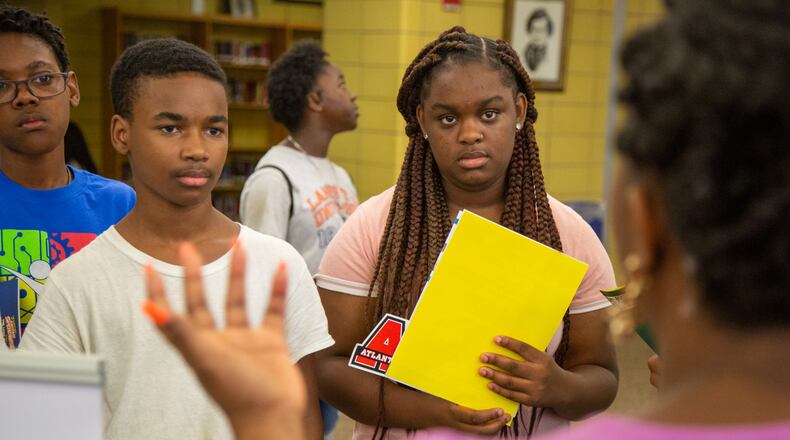 (Left to right) Curtis Evans, Jeremiah Williams and Siera McMullin listen to a college recruiter during a college and career expo hosted at Fredrick Douglass High School, in Atlanta, on Wednesday, July 24, 2019, as part of a program targeting recent Atlanta high school graduates.