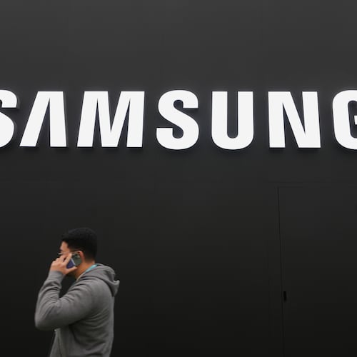 A person walks by a logo of Samsung Electronics at an exhibition hall for the Asia-Pacific Economic Cooperation (APEC) in Gyeongju, South Korea, Thursday, Oct. 30, 2025. (AP Photo/Lee Jin-man)