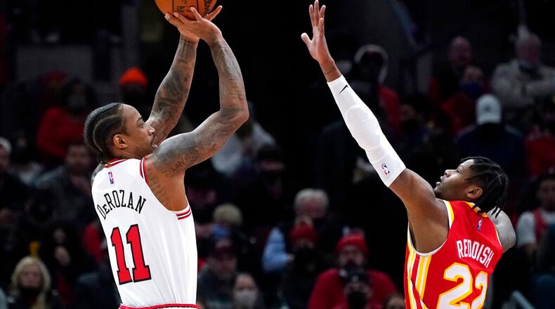 Chicago Bulls forward DeMar DeRozan, left, shoots over Atlanta Hawks forward Cam Reddish during the first half of an NBA basketball game in Chicago, Wednesday, Dec. 29, 2021. (AP Photo/Nam Y. Huh)