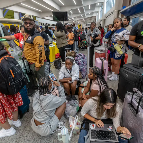 Torry Wallace (right) waits with friends and family in Terminal North for a flight to Las Vegas at Hartsfield-Jackson Atlanta International Airport on July 19, 2024. A massive outage affected Microsoft users around the globe and Atlanta-based Delta grounded its entire global flight schedule. (John Spink/AJC 2024)