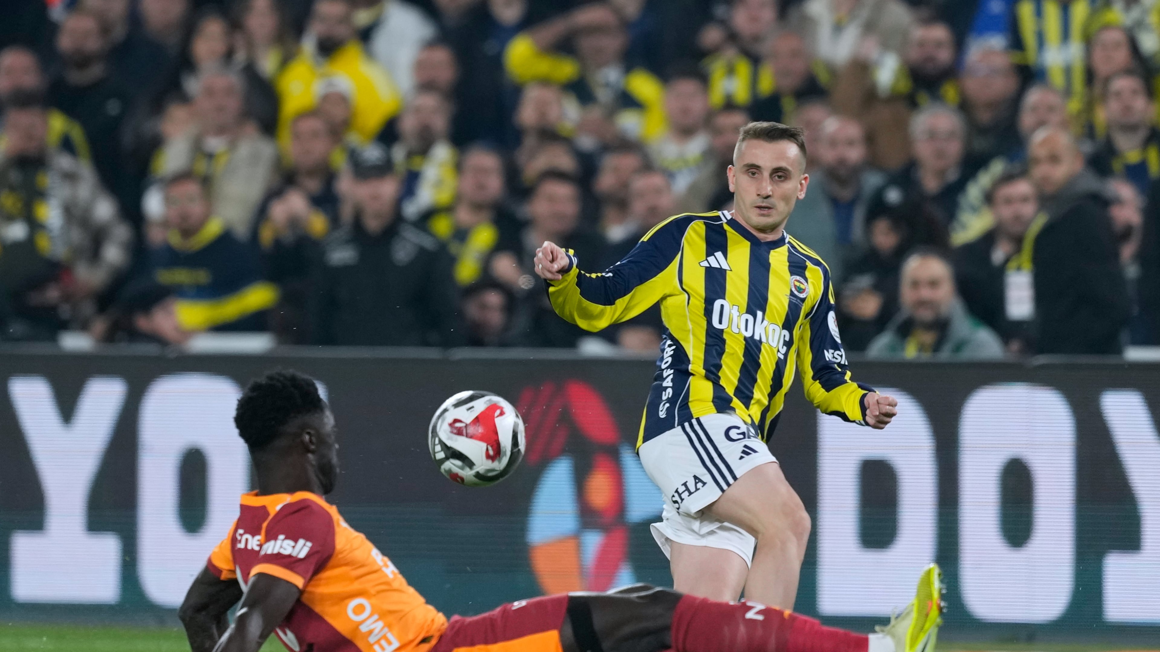Fenerbahce's Kerem Akturkoglu, right, fights for the ball with Galatasaray's Davinson Sanchez during a Turkish Super Lig soccer match between Fenerbahce and Galatasaray, in Istanbul, Turkey, Monday, Dec. 1, 2025. (AP Photo/Khalil Hamra)