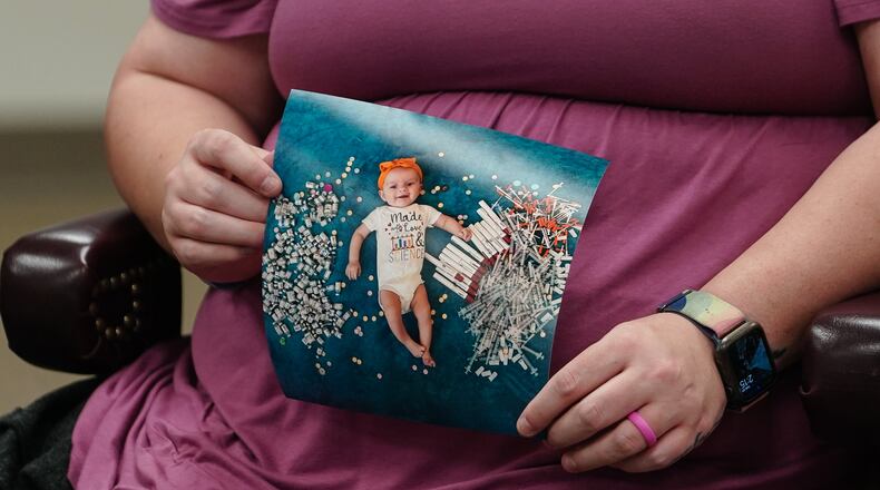 Elizabeth Goldman, an in-vitro fertilization patient at the University of Alabama at Birmingham, holds up a photo of her daughter who was born via the procedure. (ELIJAH NOUVELAGE/GETTY IMAGES)