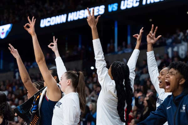 The UConn bench reacts after guard Paige Bueckers made a three-point shot during the first half against Southern California in the Elite Eight of the NCAA college basketball tournament Monday, March 31, 2025, in Spokane, Wash. (AP Photo/Jenny Kane)