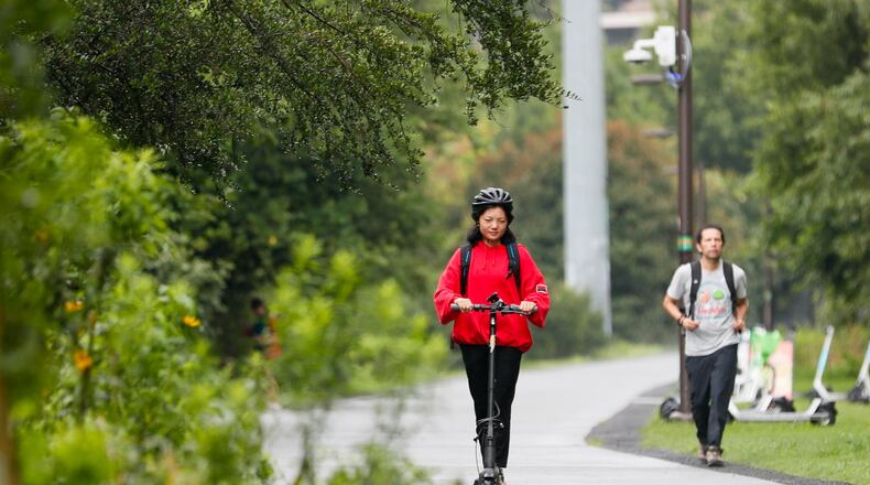 A scooter rider and a jogger both enjoy the Beltline on July 22 in Atlanta. (Miguel Martinez/AJC 2024)