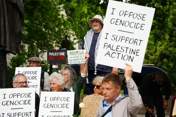 People take part in a protest in support of 'Palestine Action', organised by the Defend Our Juries group, in front of the Mahatma Gandhi statue in Parliament Square in London, England, Saturday, July 5, 2025. (Jeff Moore/PA via AP)