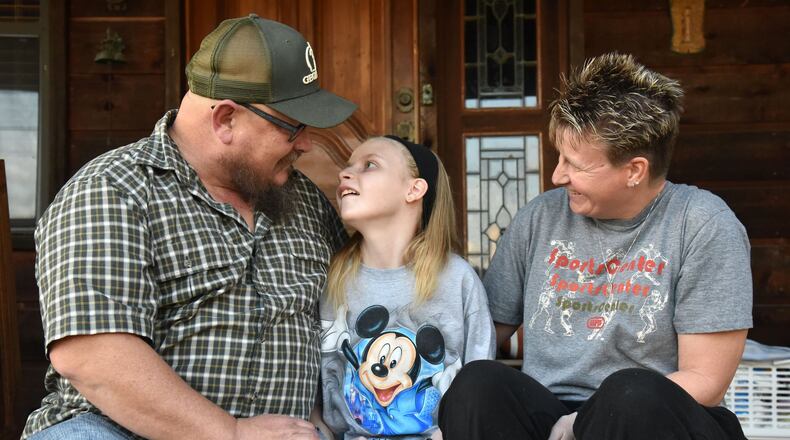 Jim “J-Bo” Wages and his wife, Lisa, comfort their daughter Sydney, 13, at their home in Dallas on Wednesday. While proponents have sought a broad expansion of Georgia’s limited legalization of medical marijuana and found a likely refuge in the state House, the Georgia Senate this year has quietly moved ahead with a plan that would downsize a key component of the nascent program and alienate dozens of families and children currently allowed to possess cannabis oil to help treat debilitating conditions. HYOSUB SHIN / HSHIN@AJC.COM