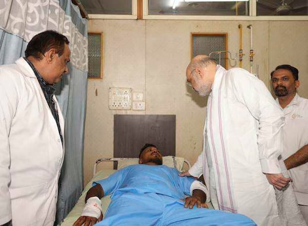 This handout photo issued by the Indian Ministry of Home Affairs shows Home Affairs Minister Amit Shah meeting British plane crash survivor Vishwash Kumar Ramesh, 40, at a hospital in Ahmedabad, after Air India confirmed Mr Ramesh was the sole survivor of the 242 people on board the London-bound Boeing 787 Dreamliner when it crashed into a medical college shortly after take-off from Ahmedabad airport. (Ministry of Home Affairs India via AP)