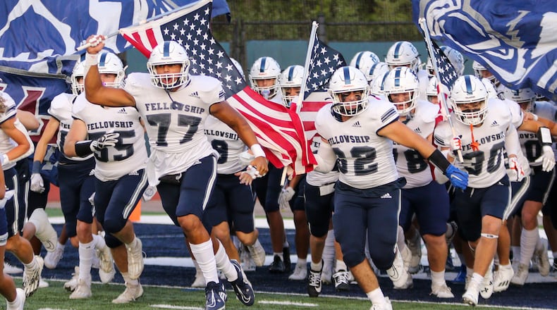 Josh Petty (77) leads the Fellowship Christian School football team on the field. (Leigh-Ann Thompson/Fellowship Christian School)