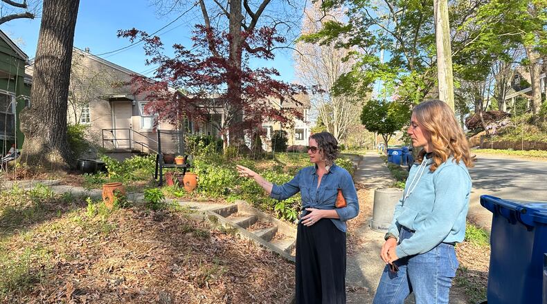 Brandy Hall (left), CEO of Shades of Green Permaculture, and Roxy Drew, caretaking director, survey a wild growth lawn in a southeast Atlanta neighborhood. (Nedra Rhone/AJC)