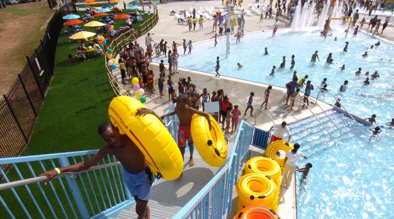 Kendric Taylor (front) makes his way up the stairs of one of the water slides at the Browns Mill Aquatic Center. Renee’ Hannans Henry/AJC.