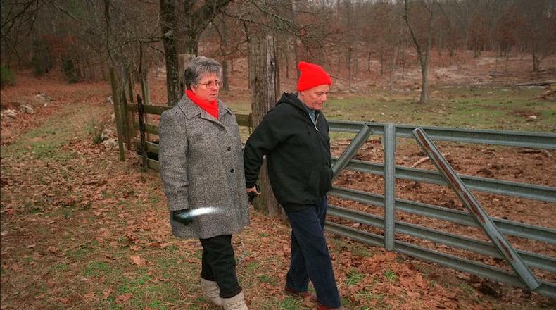 From 1999: Roy Stoner walks his wife Mary back to their home in Adairsville, after Mary visits the grave of their daughter Mary Frances Stoner. The grave is behind their house and up a hill. The girl was raped and murdered when she was 12 years old, which at that point had been 20 years ago.