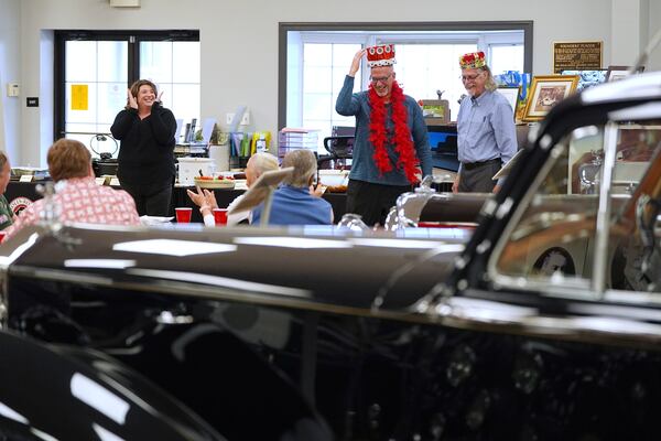 Sarah Holibaugh, left, head librarian and archivist at The Rolls-Royce Foundation applauds Randy Churchill,, center, as he is crowned volunteer of the year by the previous year's honoree Tommy Tate in Mechanicsburg, Pa., Saturday, April 5, 2025. (AP Photo/Matt Rourke)